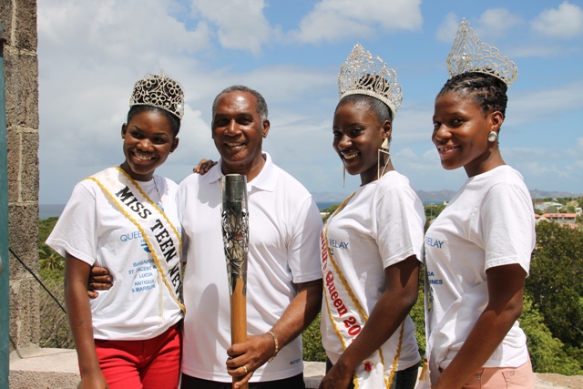 Premier of Nevis Hon. Vance Amory, Miss Teen Nevis Irveeka Nisbett, Miss Culture Jomelle Elliott and Miss Culture Swimwear Cherissa Maynard display Queen's Baton at the Apron of the Nevis Island Administration Building at Bath Plain