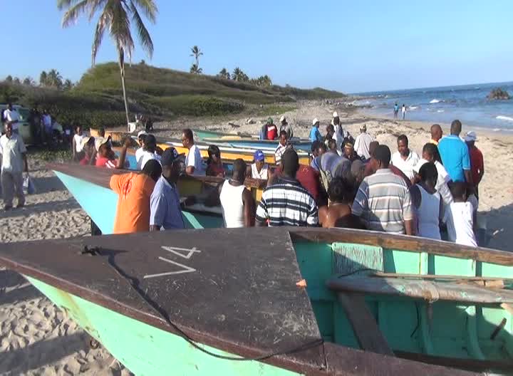 Members of the public gather round the fishing boats to purchase fish caught during the Hanley’s Road Fisherfolk Association’s Inaugural Fishing Tournament at the Indian Castle Beach on May 05, 2014