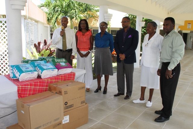(l-r) Hospital Administrator Gary Pemberton, Vice President of the Nevis Association of South Florida Avonelle Hanley, Supervisor of the Flamboyant Nursing Home Ena Sutton, Acting Premier of Nevis and Minister of Health in the Nevis Island Administration Hon. Mark Brantley, Acting Matron at the Alexandra Hospital Sister Andriene Ward-Stanley and Assistant Hospital Administrator Johnson Morton during a handing over ceremony at the Flamboyant Nursing Home on May 19, 2014