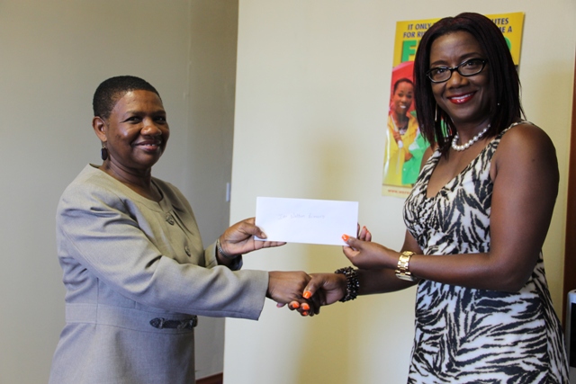 Vice President of the Nevis Association of South Florida Avonelle Hanley (right) officially handing over a check to the Principal Education Officer in the Department of Education Palsy Wilkin at a handing over ceremony at the Department of Education of May 20, 2014