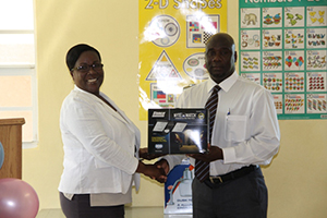 Minister in the Nevis Island Administration handing over a quantity of security lighting to Permanent Secretary of the Ministry of Education Mrs. Lornette Queeley-Connor for schools on Nevis moments after he received them from Regional Security Project Manager of Crime Stoppers St. Kitts and Nevis Mr. Veron Lake at the Department of Education’s Conference Room at Pinney’s Industrial Site on October 31, 2014