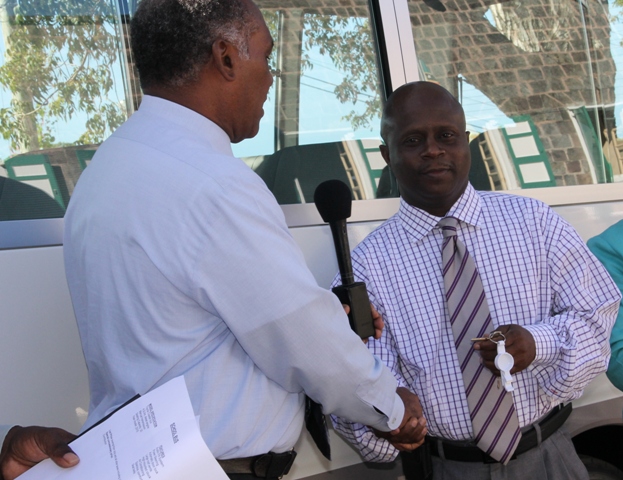 Premier of Nevis and Minister of Education Hon. Vance Amory hands the keys to a new Toyota Coaster Bus for the Department of Education to Permanent Secretary in the Premier’s Ministry Wakely Daniel on January 08, 2014 at Bath Hotel