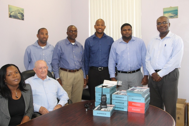 (Seated l-r) Assistant Secretary in the Ministry of Communication and Works Renè Walters and Manager of the Caribbean Development Bank Water Project Brian Kennedy. (Standing l-r) Manager of the Nevis Water Department Roger Hanley, Principal Assistant Secretary in the Ministry of Communication and Works Denzil Stanley, Director of Public Works Department Raoul Pemberton, Junior Minister in the Ministry of Communication and Works Troy Liburd and Permanent Secretary in the Ministry of Communication and Works Ernie Stapleton at the Nevis Island Administration Conference room on June 25, 2012 with the 12 short range two-way radios, a gift from Mr. Liburd