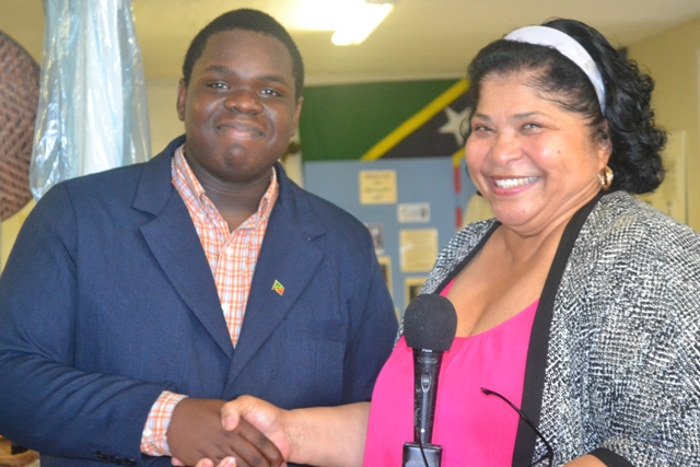 Executive Director of the Nevis Historical Conservation Society Evelyn Henville congratulates Rol-J Williams on August 05, 2015 during a send-off ceremony at the NHCS office, on his selection to represent St. Kitts and Nevis at the United States Government and World Learning 2015 Youth Ambassadors Program in Vermont, USA