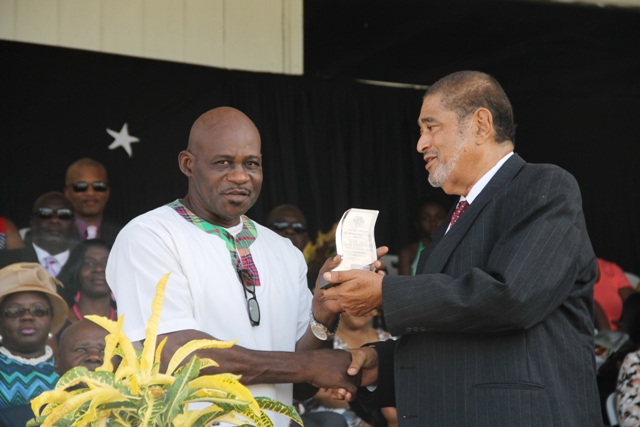 Former Police Officer Joseph Liburd receiving his award for his sterling contribution in the area of Law Enforcement from Deputy Governor General His Honour Eustace John at the 32nd Anniversary Independence Ceremonial Parade and Awards Ceremony at the Elquemedo T. Willet Park on September 19, 2015