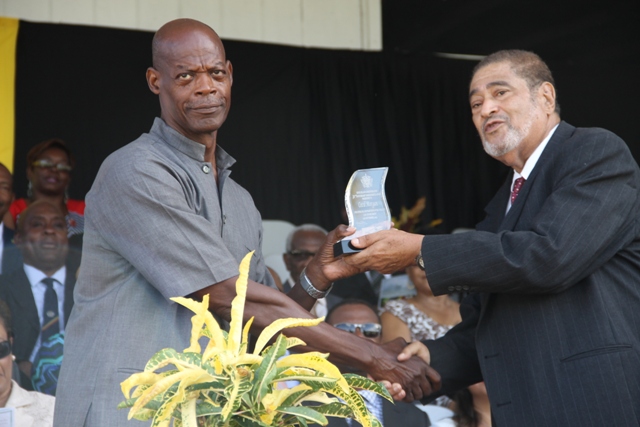 Former Police Officers Cecil Morgan receiving his award for his sterling contribution in the area of Law Enforcement from Deputy Governor General His Honour Eustace John at the 32nd Anniversary Independence Ceremonial Parade and Awards Ceremony at the Elquemedo T. Willet Park on September 19, 2015