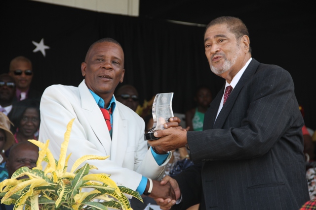 Ralph Allen receiving his award for his sterling contribution in the area of Culture from Deputy Governor General His Honour Eustace John at the 32nd Anniversary Independence Ceremonial Parade and Awards Ceremony at the Elquemedo T. Willet Park on September 19, 2015