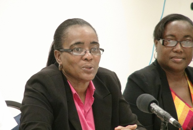 (L-R) Head of the Small Enterprise Development Unit in the Ministry of Finance Catherine Forbes and facilitator Alexa Pemberton during the closing ceremony for the Small Enterprise Development Unit’s Quick Books Accounting workshop with a certificate of completion at the Nevis Disaster Management Department‘s conference room at Long Point on October 23, 2015