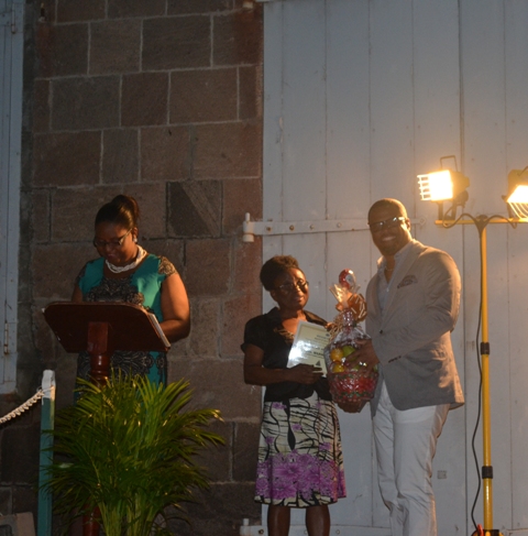 Minister of Social Development on Nevis Hon. Mark Brantley presents honouree Marjorie Brandy of the St. Georges Parish with a certificate of appreciation at the annual Charlestown Christmas Tree lighting Ceremony on December 02, 2015, for his outstanding contribution to the community