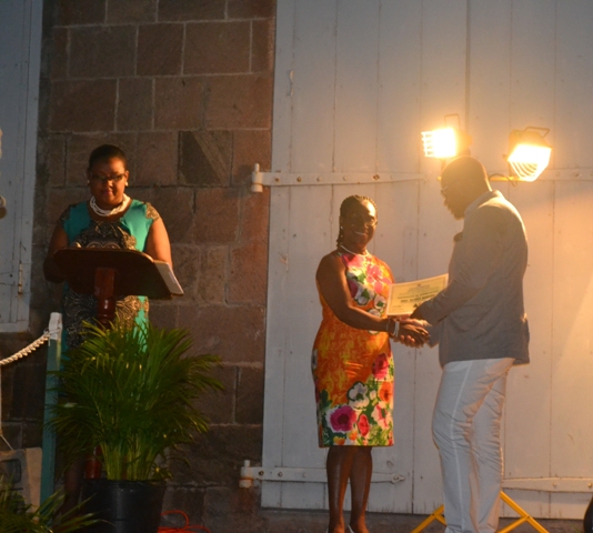 Minister of Social Development on Nevis Hon. Mark Brantley presents honouree Gloria Esdaille of the St. Paul’s Parish with a certificate of appreciation at the annual Charlestown Christmas Tree lighting Ceremony on December 02, 2015, for his outstanding contribution to the community