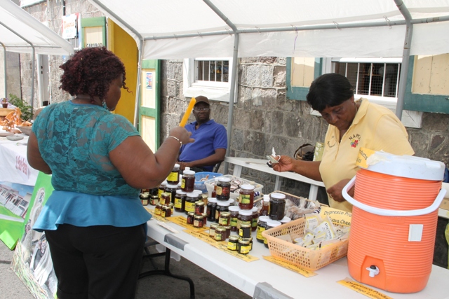 A patron purchasing a product from Agro-Processor Olvis Dyer of Dypresco Products at the Department of Community Development’s Community Day Fair in Charlestown on May 20, 2016