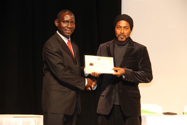 Photographer Sylvester Meade, the first winner of the Ministry of Tourism’s Amateur Photographer of the Year contest accepting the winner’s certificate from John Hanley, Assistant Secretary in the Ministry of Tourism at the awards ceremony in 2016 (file photo)