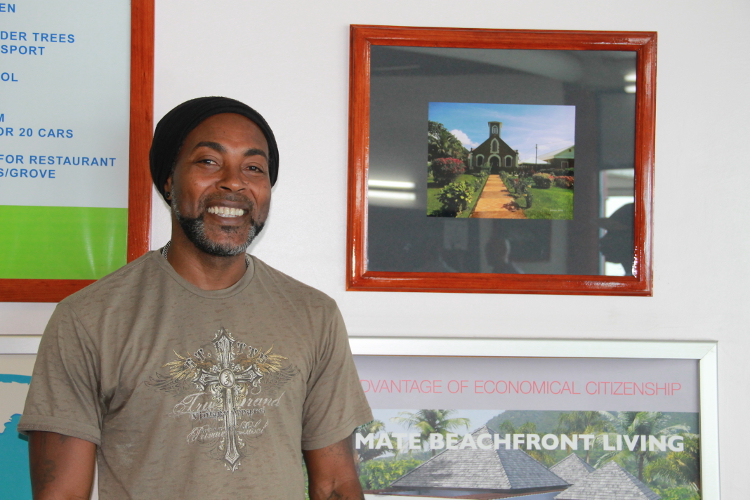 Photographer Sylvester Meade, the first winner of the Ministry of Tourism’s Amateur Photographer of the Year contest with one of his winning entries on display at the Vance W. Amory International Airport (file photo)