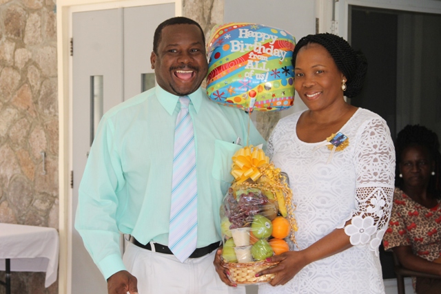 Keith Glasgow, Permanent Secretary in the Ministry of Social Development presents a gift basket on behalf of the ministry and Department of Social Services to Mervette Powell, granddaughter of 105-year-old birthday girl Celian “Martin” Powell on behalf of her great-grandmother at a birthday celebration on January 19, 2017 at the Flamboyant Nursing Home