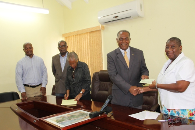 Dr. Robertine Chaderton, Chairman St. Kitts and Nevis Sugar Diversification Foundation hands over a cheque to Hon. Vance Amory, Premier of Nevis and Minister of Finance in the Nevis Island Administration at the Ministry of Finance conference room in Charlestown on February 14, 2017. It is the second draw-down from funds for the construction of the 400 meter athletic Mondo track at Long Point. Looking on are (l-r) Counsellors Leon Lescott and Delara Taylor and Secretary to the Board Marguerite Foreman