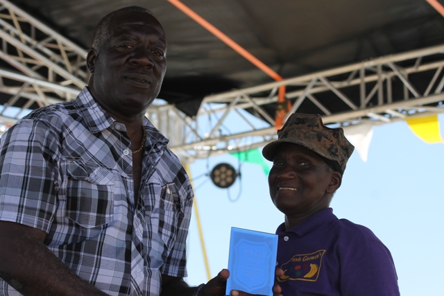 Augustine Merchant, IICA Coordinator for the Delegation in St. Kitts and Nevis presents a plaque to Mrs. Emmontine Thompson for her Outstanding Performance and Contribution to the Crops Sector in 2016 at the 23rd Annual Agriculture Open Day at the Villa Grounds on Nevis on March 30, 2017