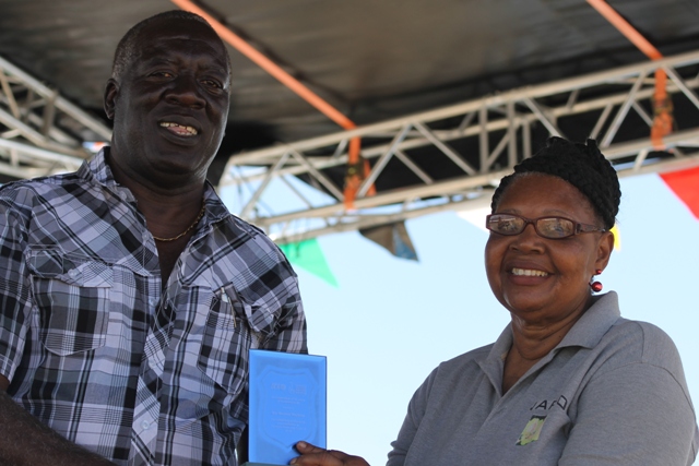 Augustine Merchant, IICA Coordinator for the Delegation in St. Kitts and Nevis presents a plaque to Mrs. Maureen Stapleton for her Outstanding Performance and Contribution to the Agro-Processing Sector for 2016 at the 23rd Annual Agriculture Open Day at the Villa Grounds on Nevis on March 30, 2017