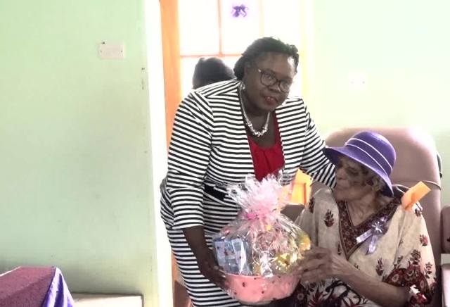 Hon. Hazel Brandy-Williams, Junior Minister responsible for seniors on Nevis presents Eileen Swanston Smithen with a birthday gift at a thanksgiving service in celebration of her 100th birthday on June 20, 2017, at the Zion Gospel Hall
