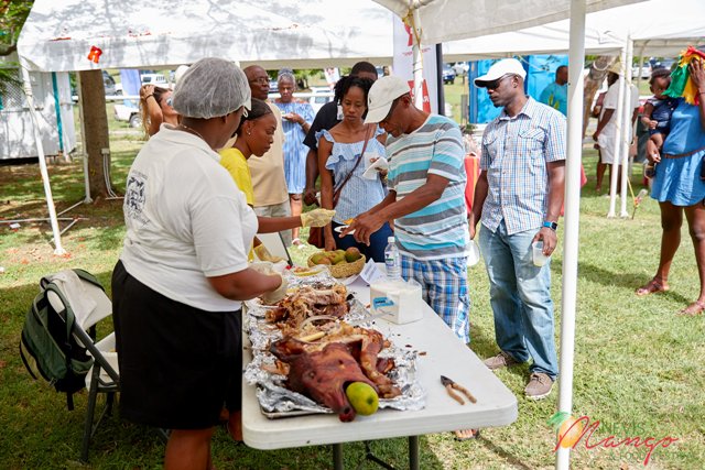 Patrons at the Nevis Tourism Authority’s Nevisian Chef Mango Feast sampling The Hermitage Plantation Inn’s mango infused whole roast pig at Oualie Beach on July 07, 2017 (photo courtesy the Nevis Tourism Authority)