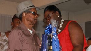 Hon. Hazel Brandy-Williams, Junior Minister in the Ministry of Social Development presents a gift basket to Mr. James Lewis Wilkinson, one of five men honoured for their contribution to cultural preservation on Nevis