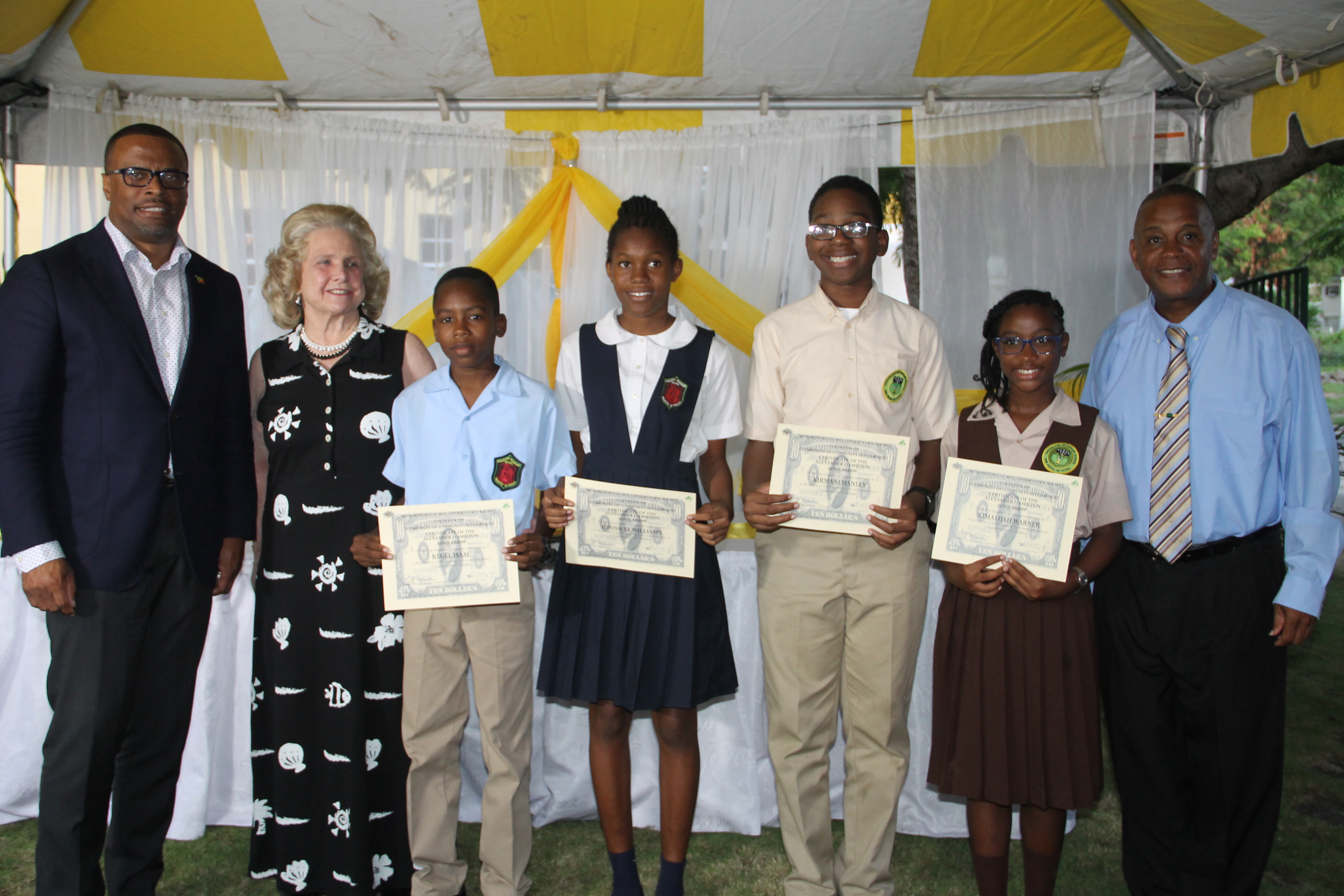 Premier of Nevis Mark Brantley, Mrs. Mary Anne Hamilton Great-great grand daughter of Alexander Hamilton, Mr. Kegel Isaac, Ms. Jonnicia Williams, Mr. Kirmani Hanley, Ms. Kimalijah Warner and Hon. Eric Evelyn - Minister of Youth and Community Development at the Alexander Hamilton Scholarship Award Ceremony on January 12, 2018, at the Alexander Hamilton Museum grounds