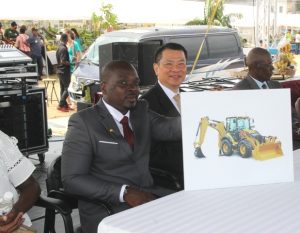 Director of the Department of Agriculture on Nevis Mr. Randy Elliott (right) flanked by Resident Ambassador to St. Kitts and Nevis His Excellency Chiou Gow-Wei, showing off an image of the US$140,000 backhoe, a gift from the Republic of China (Taiwan) to the Department of Agriculture at the opening ceremony of the Department’s 24th Annual Open Day at the Villa Grounds on March 22, 2018