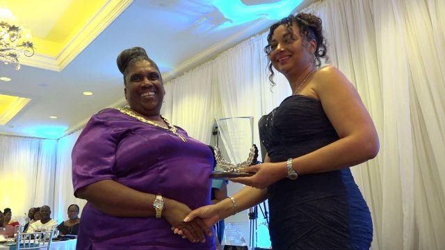 First Lady Mrs. Sharon Brantley (right) presents Ms. Sara-Ann Daniel, Operations Manager of Golden Rock Inn with the Ministry of Tourism’s Hotel of the Year Award at the ministry’s Tourism Awards Gala and Dance at the Four Seasons Resort, Nevis on May 26, 2018