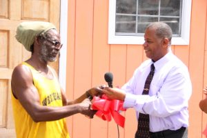 Hon. Eric Evelyn, Minister responsible for Social Development on Nevis presents the keys to a new home at Spring Hill to Joseph Belgrave at a handing over ceremony on June 14, 2018