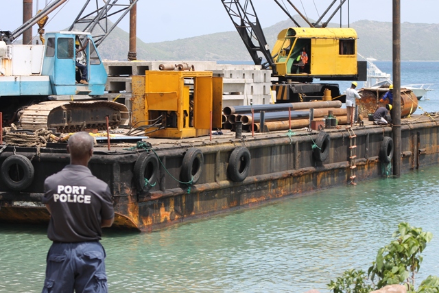 Workmen on a barge putting in pilings for the new water taxi pier at Oualie Bay on June 18, 2018