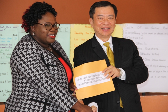 His Excellency George Gow-Wei Chiou, Republic of China (Taiwan) Resident Ambassador to St. Kitts and Nevis presents Hon. Hazel Brandy-Williams, Junior Minister of Health with a cheque on June 12, 2018 at the Franklin Browne Community Centre in Newcastle  to purchase media equipment  for the Health Promotion Unit