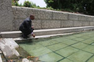 Hon. Mark Brantley, Premier of Nevis and Minister of Tourism takes a closer look at one of the pristine pools decked with new slabs at the Bath Stream in Bath Village on June 25, 2018