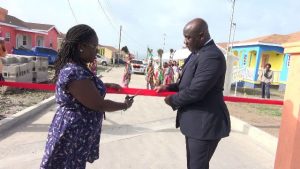 Mrs. Tracy Frazer, a homeowner at Cedar View Housing Development at Maddens, cuts the ribbon with Hon. Alexis Jeffers, Minister responsible for Housing and Lands, and Chairman of the Nevis Housing and Land Development Corporation Board of Directors at the official opening on September 20, 2018
