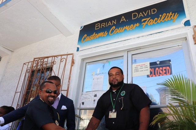 Hon. Mark Brantley, Premier of Nevis, and Mr. Sheldon David, the son of the late Brian Anthony David being congratulated by Mr. Cynric Carey, Deputy Comptroller of the Customs and Excise Department on Nevis moments after the ribbon cutting and unveiling of the new name of the Customs Courier Facility in Charlestown on October 25, 2018