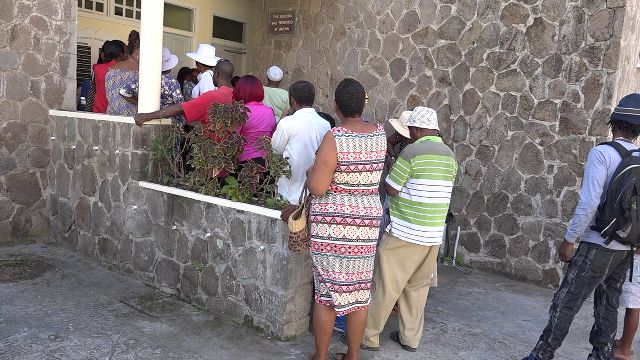 Persons lined up at the Nevis Island Administration building in Charlestown to receive their first $500 cheque from the Federal government’s Poverty Alleviation Programme on December 24, 2018