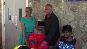 Ms. Celian “Martin” Powell, the oldest person in St. Kitts and Nevis at her 107th birthday celebration at the Flamboyant Nursing Home on January 19, 2019, flanked by (left) Her Excellency, Hyleta Liburd, Deputy Governor General on Nevis and (right)  Hon. Eric Evelyn, Minister of Social Development in the Nevis Island Administration  and Mrs. Dulcina Brown, Ms. Powell’s daughter