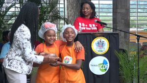 Mrs. Shelisa Martin-Clarke Acting Permanent Secretary in the Ministry of Health presents a trophy to joint 1st place winners in the MyHealthyPlate Junior Chef Competition, to Ms. Lanaiva Jones and Ms. Di Tricia France of the Charlestown Primary School, at the Nevis Performing Arts Centre courtyard on April 15, 2019