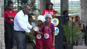 Mr. Randy Elliott, Director of Agriculture presents joint 3rd place winners in the MyHealthyPlate Junior Chef Competition, to Mr. Aaron Woolward and Ms. J' rell Powell  of the Ivor Walters Primary School, at the Nevis Performing Arts Centre courtyard on April 15, 2019