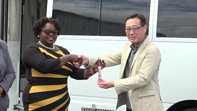 Mr. Yuji Takeuchie General Manager of Futurebud International Co. Ltd. hands over the keys for a mobile medical vehicle on behalf of the government and people of Japan to Hon. Hazel Brandy Williams, Junior Minister of Health on Nevis at the Nevis Disaster Management Department grounds on May 29, 2019