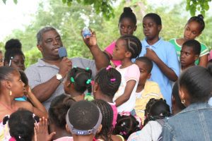 Hon. Malcolm Guishard of blessed memory with children of the St. John’s Parish delivering gifts at Christmas time in December 2005 (file photo)