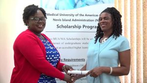 Hon. Hazel Brandy-Williams presents MUA/NIA Scholarship award to Ms. Hyacinth Ferguson, on behalf of her son Ryani Ferguson, at the Ministry of Finance Conference Room in Charlestown on July 17, 2019 to pursue a Bachelor of Science in Mathematics with a Minor in Mechanical Engineering