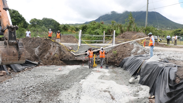 Workers from contractors Surrey Paving and Aggregate Co. Caribbean Ltd. laying the foundation for the installation of a box culvert to alleviate flooding in the Cades Bay area on July 29, 2019