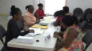 Some of the 361 Four Seasons Resort, Nevis workers affected by a temporary closure receiving assistance cheques from the Nevis Island Administration through staff of the Treasury Department at the St. Paul’s Anglican Church Hall in Charlestown on August 21, 2019