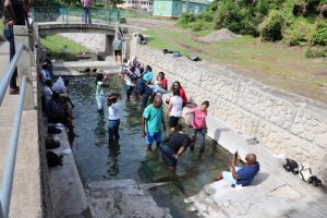 Delegates of the Caribbean Water and Wastewater Association conference in St. Kitts taking a dip in the thermal Bath Stream during a tour of Nevis on October 18, 2019 