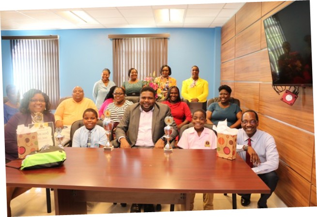 (L-r) front row, Ms. Zahnela Claxton, Principal Education Officer; Rondre Daniel, winner of the local leg of the 10th Annual OECS Courts Reading Competition; Hon. Troy Liburd, Junior Minister of Education; Khaleed Warner, third place winner in of the local leg of the 10th Annual OECS Courts Reading Competition; and Mr. Kevin Barrett, Permanent Secretary in the Ministry of Education; on November 18, 2019