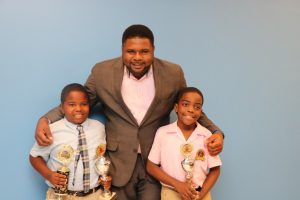 Hon. Troy Liburd, Junior Minister of Education with winners of the local leg of the OECS Courts Reading Competition. Champion Rondre Daniel of the Maude Crosse Preparatory School (left) and third place winner Khaleed Warner of the Elizabeth Pemberton Primary School at the minister’s office on November 18, 2019