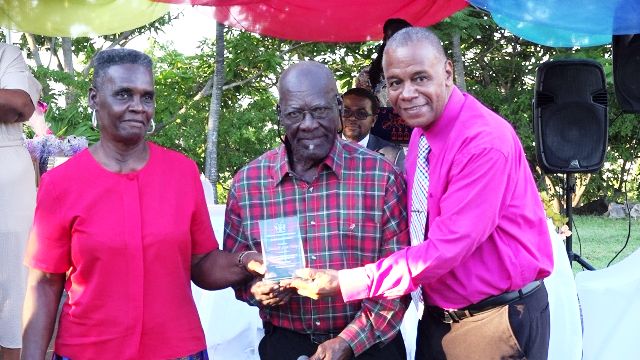 Hon. Eric Evelyn, Minister of Social Development presents gift to James and Edith Phillip on behalf of the Department Department of Social Services, Senior Citizens Division, of for their contribution to the development of Nevis at an event dubbed “Afternoon of the lawn” on the grounds of Government house at Bath Plain on October 31, 2019