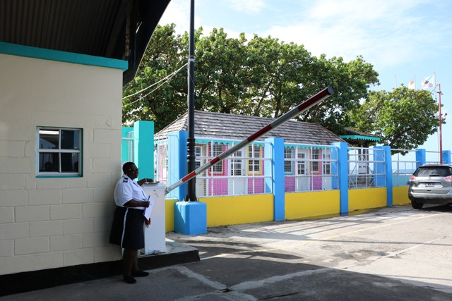 Nevis Air and Sea Ports Authority’s Port Officer Sergeant Berlyn Webbe, demonstrating use of the bar allowing vehicular entry onto the Charlestown Pier for the authority’s port entry fee effective December 16, 2019