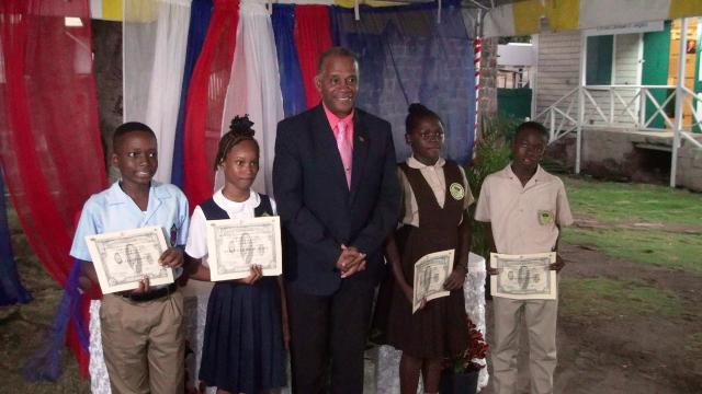 Hon. Eric Evelyn, Minister of Social Development (middle) with 2020 beneficiaries of the Alexander Hamilton Scholarship Fund (l-r) Mr. Jae-Ele Swanston; Ms. Kaya Williams-Mulraine; Ms. Noella Maynard; and Mr. Stephan Leader