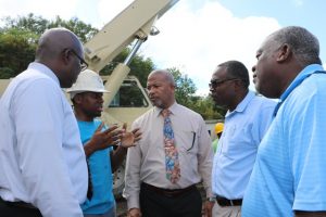 (second from left) Mr. Clychawn Wilson, Head of Water Production at the Nevis Water Department, speaking with (from his l-r) Hon. Spencer Brand, Minister of Water Services on Nevis; Mr. Denzil Stanley, Principal Assistant Secretary in the ministry; Mr. Floyd Robinson, Manager of the Water Resource Management Unit, and (left) Dr. Ernie Stapleton, Permanent Secretary in the Ministry of Water Services on site of the Hamilton well on January 16, 2020