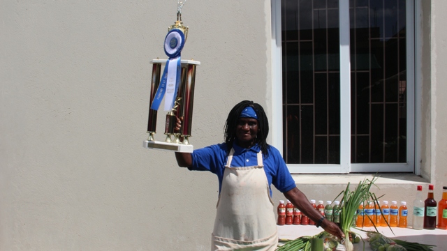 : Mrs. Emontine Thompson showing off her trophy and blue ribbon at her stall at the George Mowbray Hanley Market Complex in Charlestown, on February 24, 2020